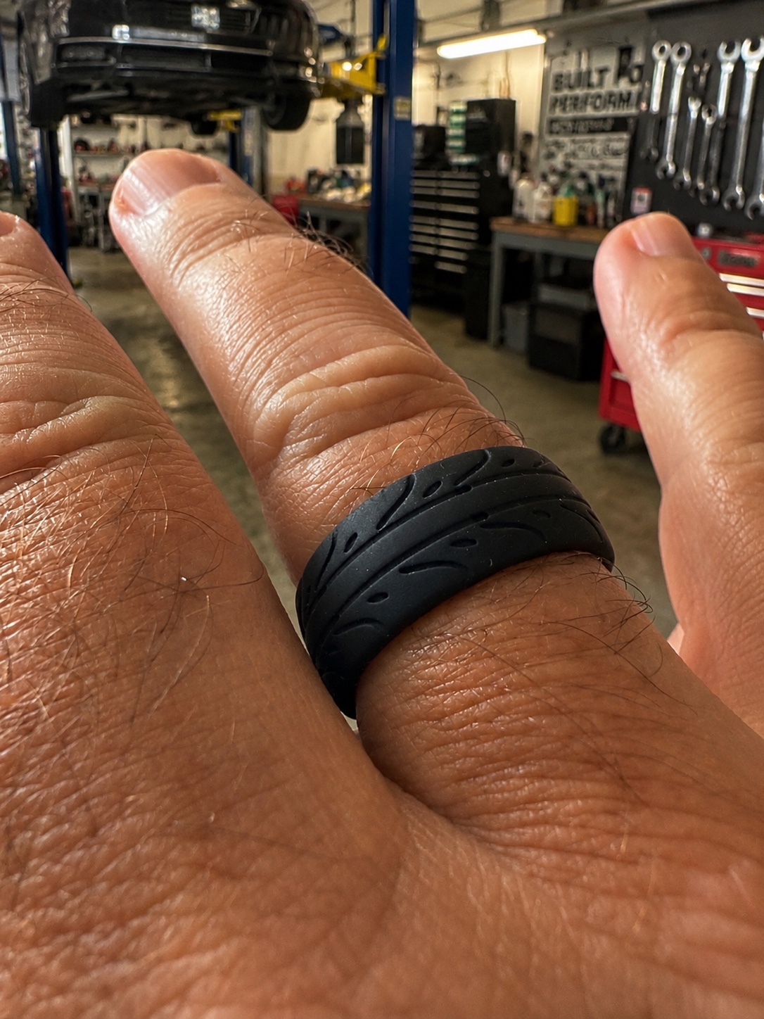 Black silicone tyre ring worn inside a working automotive garage